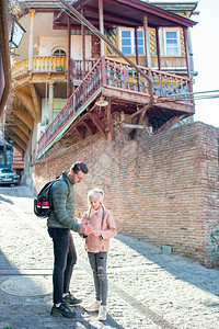 在格鲁吉亚首都第比利斯的老街区在阳光明媚的日落时家人在第比利斯市旧街区行走格鲁吉亚第比利斯市旧街区阳台砖墙屋背景