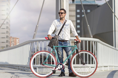 旅行城市坐在自车旁边的年轻时尚男子图片