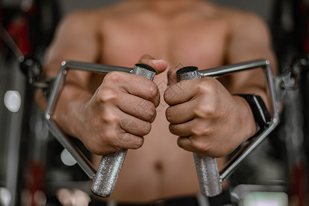 起重在室内训练体操概念一名男肌肉少年使用健身设备反复推动发展乳房一个男子运动器械健美背景图片