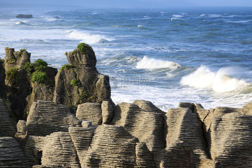 沃堆积的多于大海在煎饼岩石后面美丽的阳光下咆哮图片