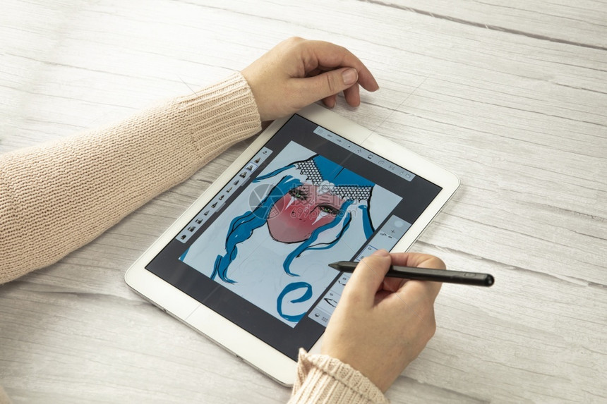 女空白的木制年轻创意设计师拿着手写笔在木桌上的数字平板电脑屏幕上绘图带有复制空间现代数字艺术顶视图空间为文本看法图片