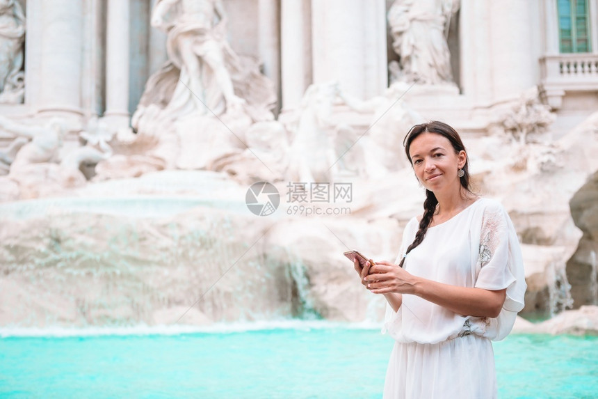 历史的正面年轻女子在意大利罗马旅行期间背景特莱维喷泉女孩享受她的欧洲假期在意大利罗马旅行期间望着特莱维喷泉的漂亮女人孩享受她的欧图片