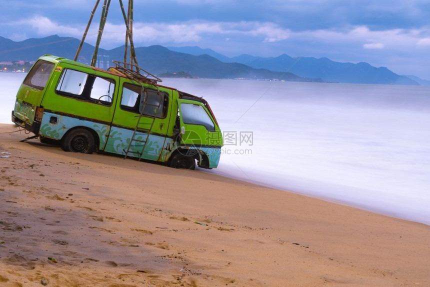 热带越野车旧停在靠近海边的滩上越南背景山和天空出租车图片