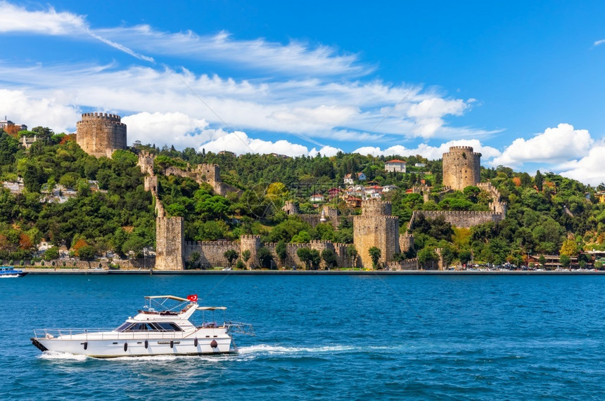 欧洲船在Bosphorus海峡航行由伊斯坦布尔RumeliHisari城堡建造火鸡筑图片