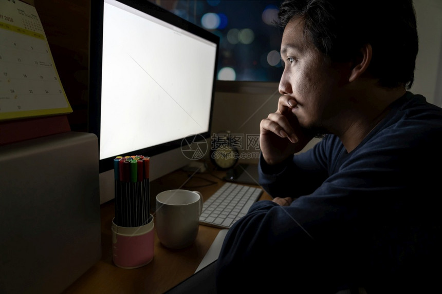 集中注意力最后期限亚洲的肖像商人坐在桌子上辛勤工作晚间在场所计算机桌面前方工作认真行动努力工作为时太晚的概念而努力工作人们图片
