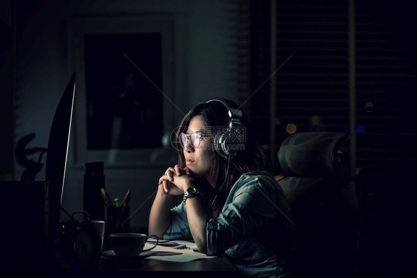 亚洲女商人坐在桌子上辛勤工作晚点在场所的电脑桌面前认真行动努力工作太迟的概念AfricaBusinessWorldWorking图片