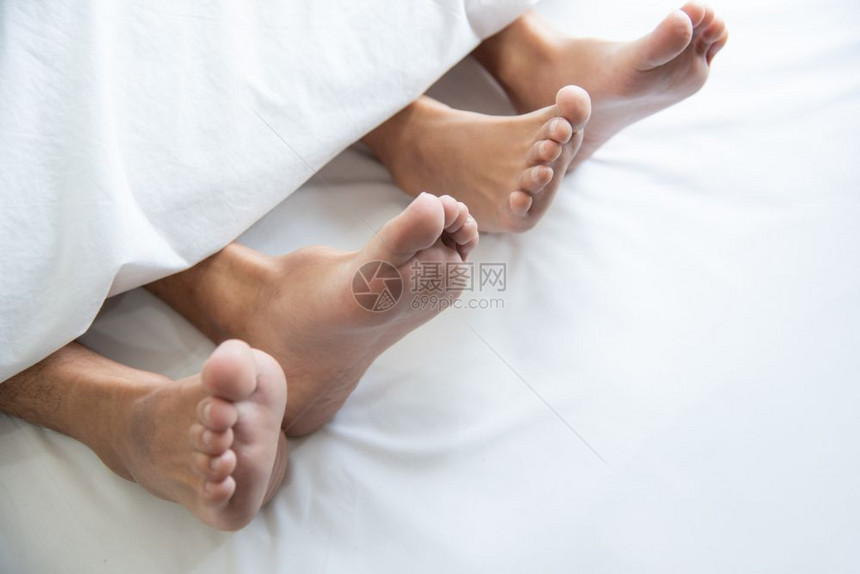 男主题在蜜月度假期的卧室里赤脚裸在毯子下紧贴一对夫妇在蜜月假日的卧房里周末很长时间在家里婚礼仪式后与浪漫人士放松男图片