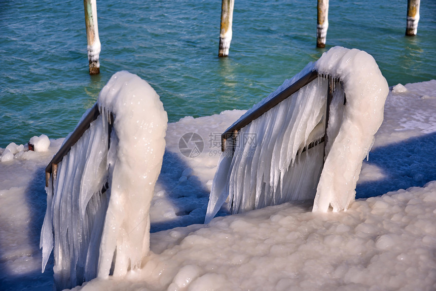 寒冷的灯塔和码头在暴风寒冬日雕塑海浪岸图片