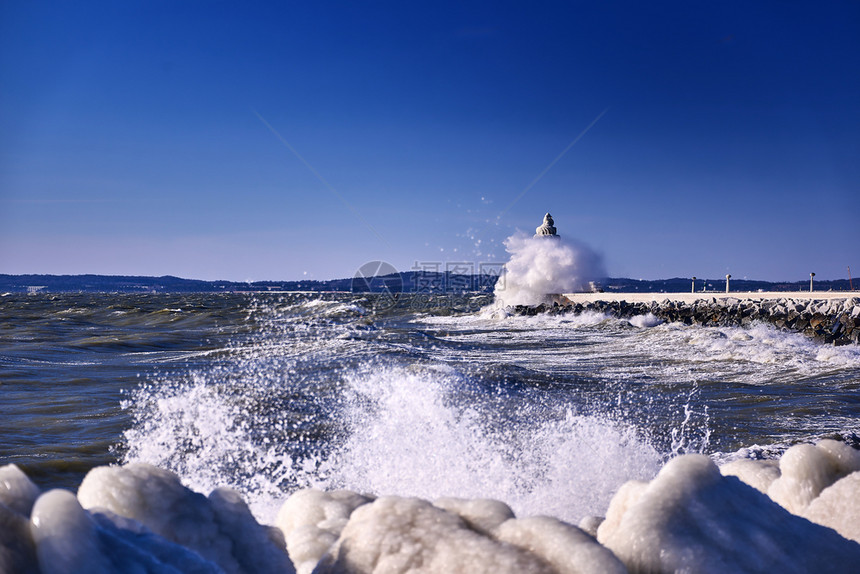 支撑海景霜寒冷的灯塔和码头在暴风寒冬日图片