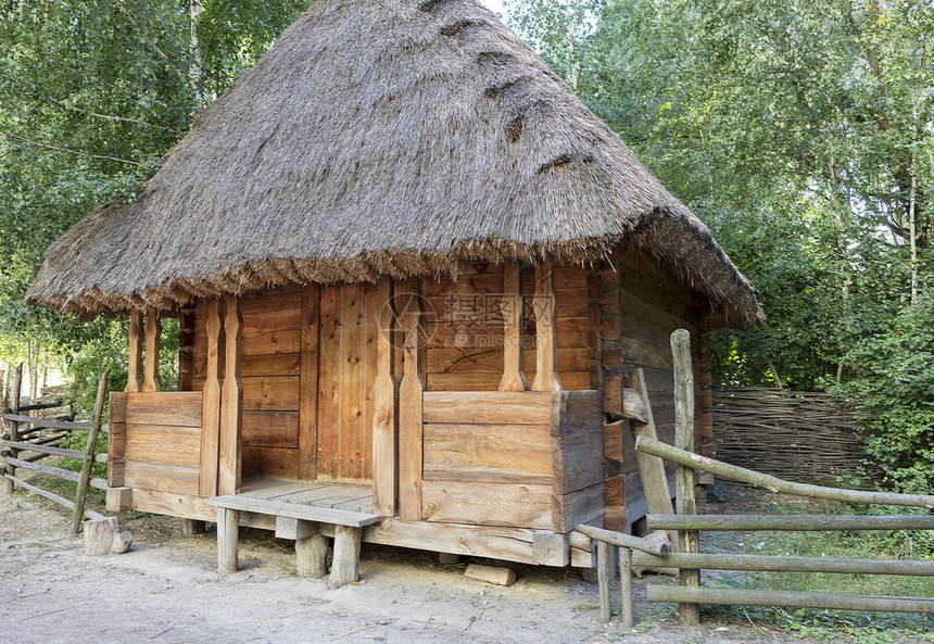 乌克兰古老的传统农村谷仓屋顶有刺破的四周有一个木头棍子栅栏在一个绿色花园子里传统的乌克兰农村谷仓上面有根稻草屋顶夏天真正的乡村图片