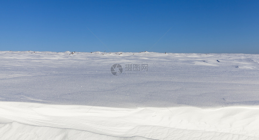 下着蓝天空深雪漂浮在一片蓝色的天空中在寒冷的天气中深雪漂流时间场景深的图片