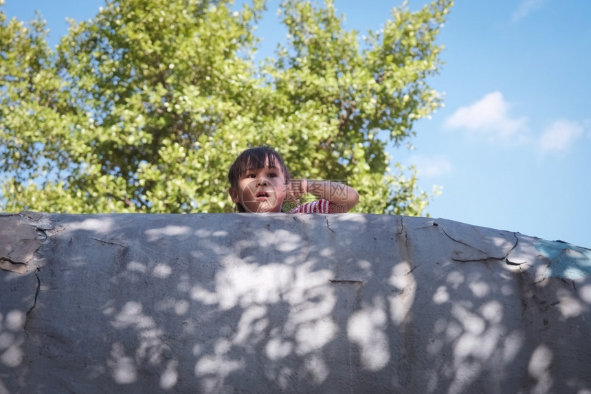 玩时间微笑的小女孩在温暖夏日操场上为照片摆出微笑的小女孩姿势家人一起度假学习图片