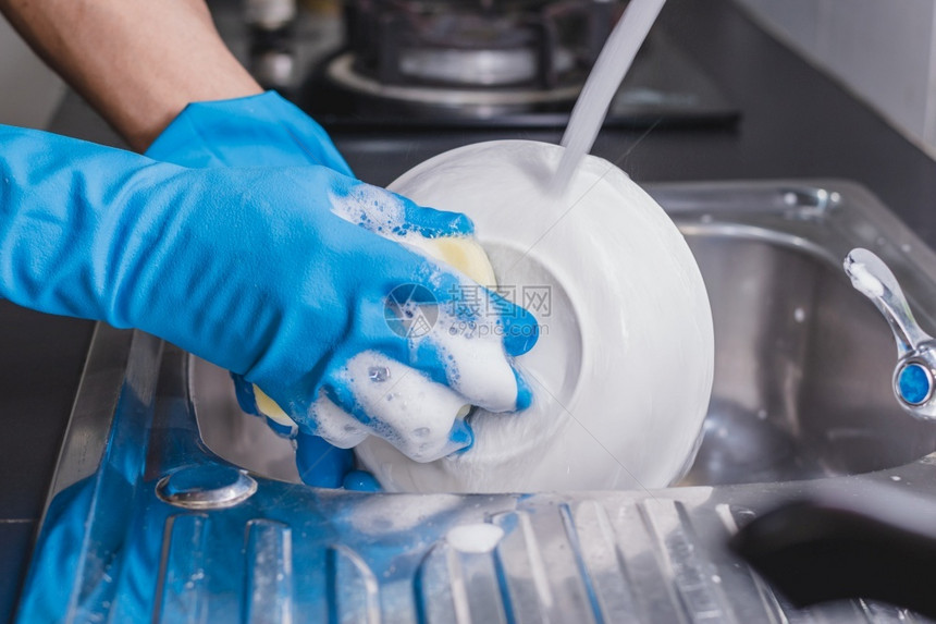 人类一个穿着蓝色橡胶手套的近身男子在厨房水槽里用洗碗液杯子他当时正戴着一个蓝色橡胶手套家务干净的图片
