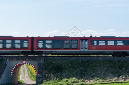 云红色列车横穿田地上的一个小过道地球交汇图片