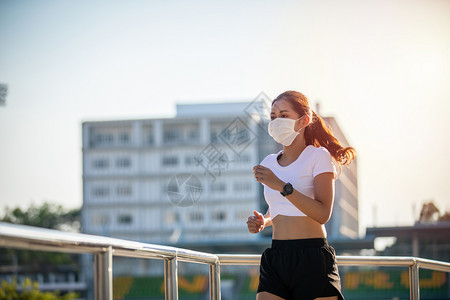 戴口罩跑步户外跑步戴着口罩的年轻女子背景
