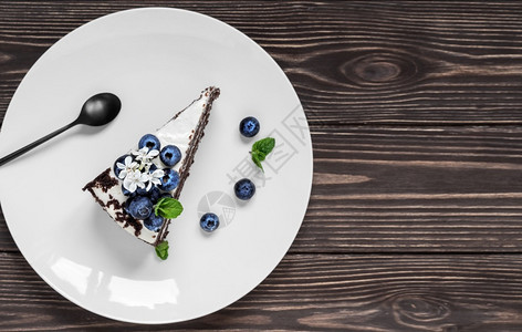 不同的土制鸡樱桃蛋糕加酸奶油装饰在白色盘子上的蓝莓和薄荷叶上西伯利亚传统蛋糕顶视面带复制空间深木背景的黑本底饼带有酸奶油的土制鸟背景图片