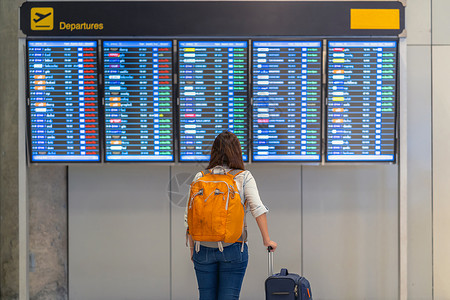 在现代机场旅行和运输概念的飞行信息屏幕登入飞行信息屏幕时背着行李站在飞板上办理登机手续的亚洲女背包车或旅行者面的携带李妇女背包车商业高清图片素材