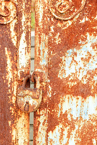锁体结构体木板金属门上旧的生锈长锁上面有生锈纹理和古老的防腐涂料喷漆垂直图像复制空间一个老的生锈锁连接了门的叶子风化背景