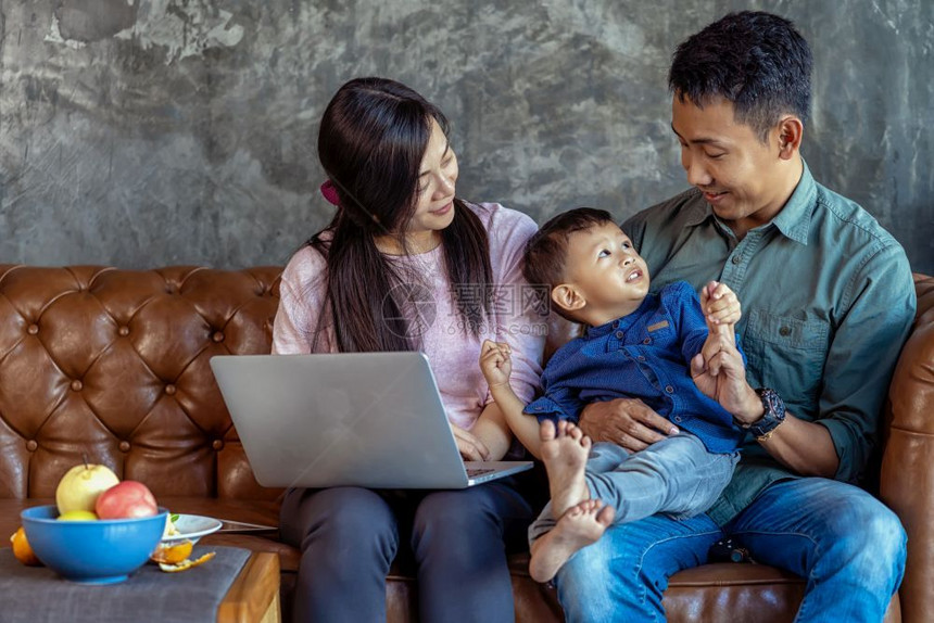 温暖的有儿子亚洲家庭正在透过技术笔记本电脑寻找漫画当生活在自学或家庭校的阁楼里时一起玩游戏家庭学校的概念FamilyhomeSc图片