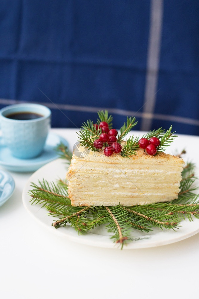 锥体桌子圣诞树背景上装饰圣诞树枝和浆果的蛋糕圣诞树背景上装饰圣诞树枝和浆果的两杯咖啡蛋糕和婚姻图片