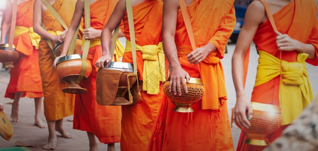 老挝僧侣新手銮老挝教科文组织世界遗产城镇LuangPrabang清晨在古老的LuangPrabang举行盛光环会时携带背景
