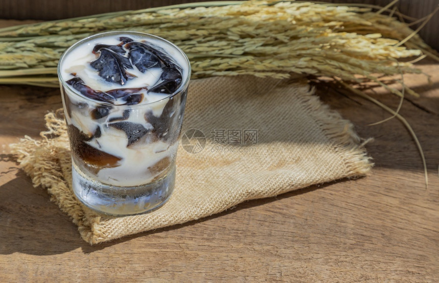 泰国一杯新鲜奶草果酱DessertShebalgelatin或果冻黑的木制背景有牛奶美食健康图片