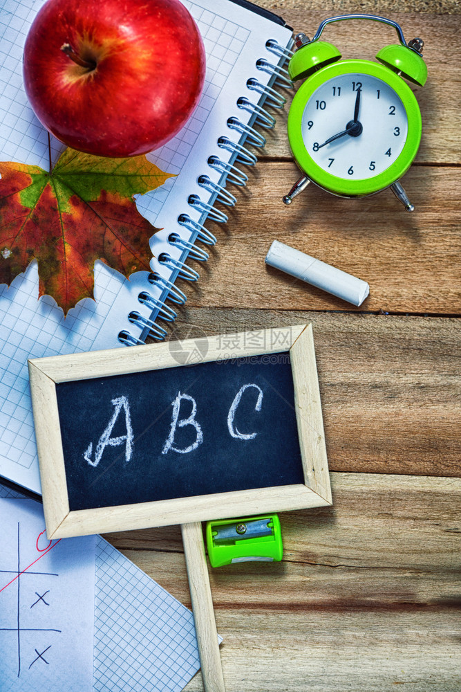 最佳颜色黑的回到学校概念警报钟计算器黑板上面写着字母ABC笔铅一小块粉末红苹果和木本背景的马普叶图片