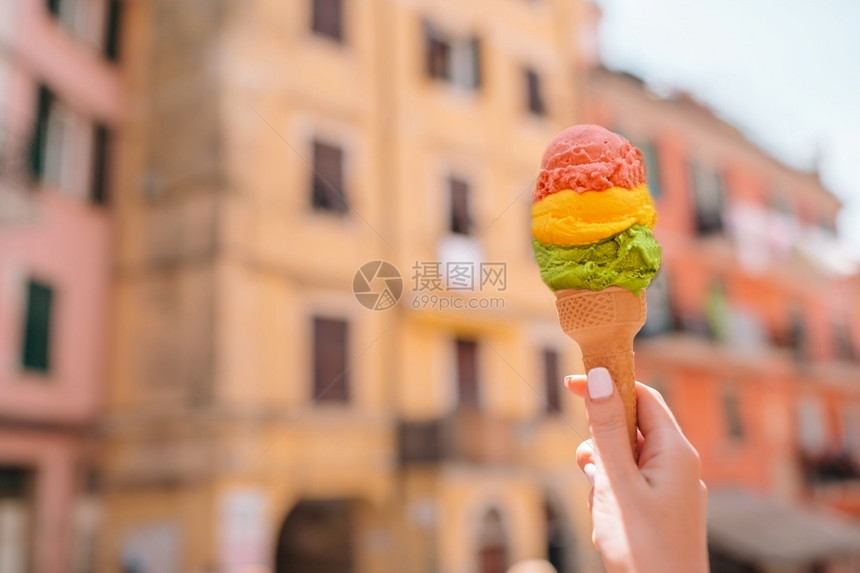 脆的糖浆结霜冰淇淋锥壳紧握在户外手中美味甜的冰淇淋贴在手边背景是意大利老村庄图片
