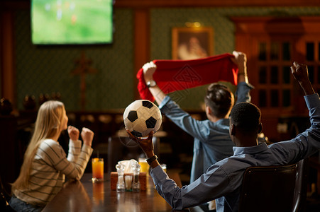 年轻朋友们在酒吧一起观看世界杯足球比赛高清图片