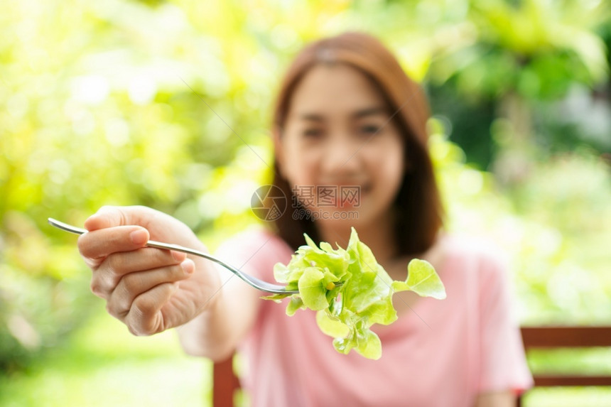 素食主义者人们蔬菜坐在花园旁边房子阳台上吃健康绿色沙拉的保健和营养食品概念她认为在家庭园圃旁边的露台里生活着一个健康的绿色沙拉图片