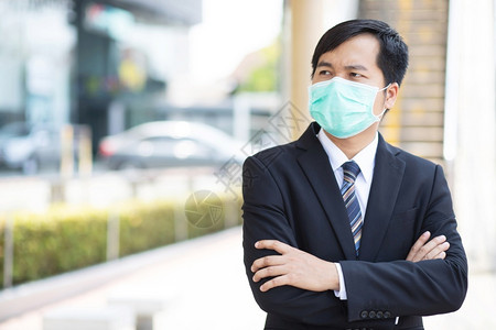 一名商人在上班前戴面罩以保护科罗纳然后到办公室工作生病的商业健康高清图片素材
