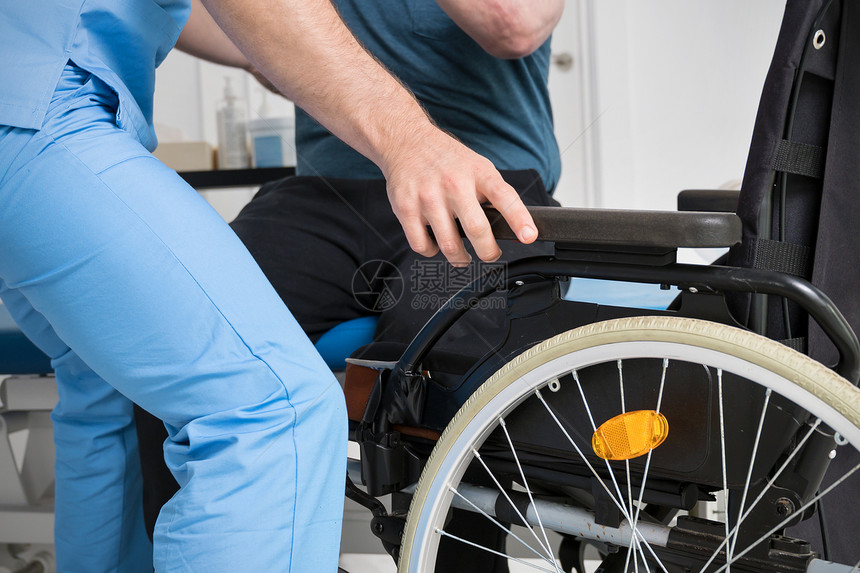 男物理治疗师帮助使用轮椅的残疾患者在康复医院起床高质量照片男物理治疗师帮助使用轮椅的残疾患者在康复医院起床人们失能依赖图片