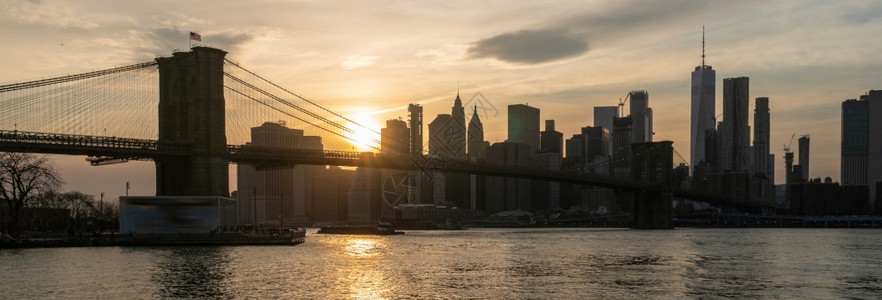 游客美国市中心天际建筑与交通概念纽约市风景和布鲁克林大桥的现场报道在日落时横跨东河位于美国市区的天际建筑与交通时间旅行水高清图片素材