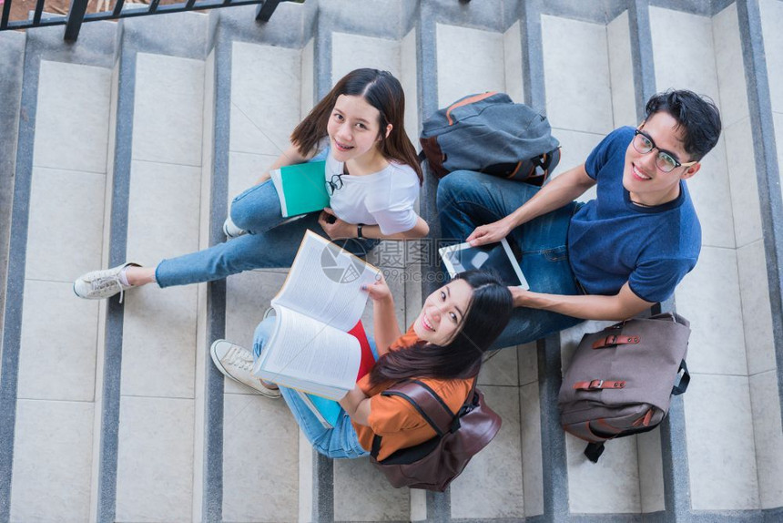 快乐的大学生一起在楼梯上向上看图片