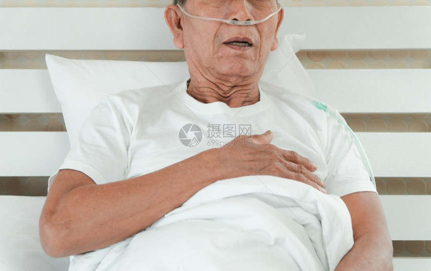 躺在医院床上并带有鼻喉呼吸管的老人图片