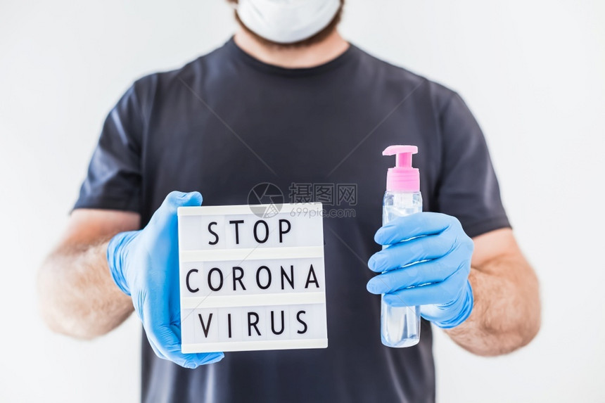 在科罗纳COVID19传染病流行期间身戴乳胶医用手套和保护面罩的人手中Coronna健康护理艾滋预防停留医疗的腐剂图片