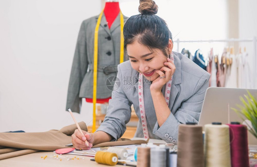 女士衣服工作场所在家庭办公室讲习班上工作的有吸引力亚洲时装设计师女时装设计师制妇女创造新的服装设计丛书裁缝和纫人民生活方式和职业图片