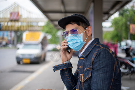 在户外戴口罩预防疾病的男性青年图片