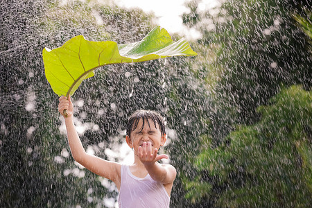 男孩微笑玩得开心站在她的头上叶子在雨中站立脸童年男生图片