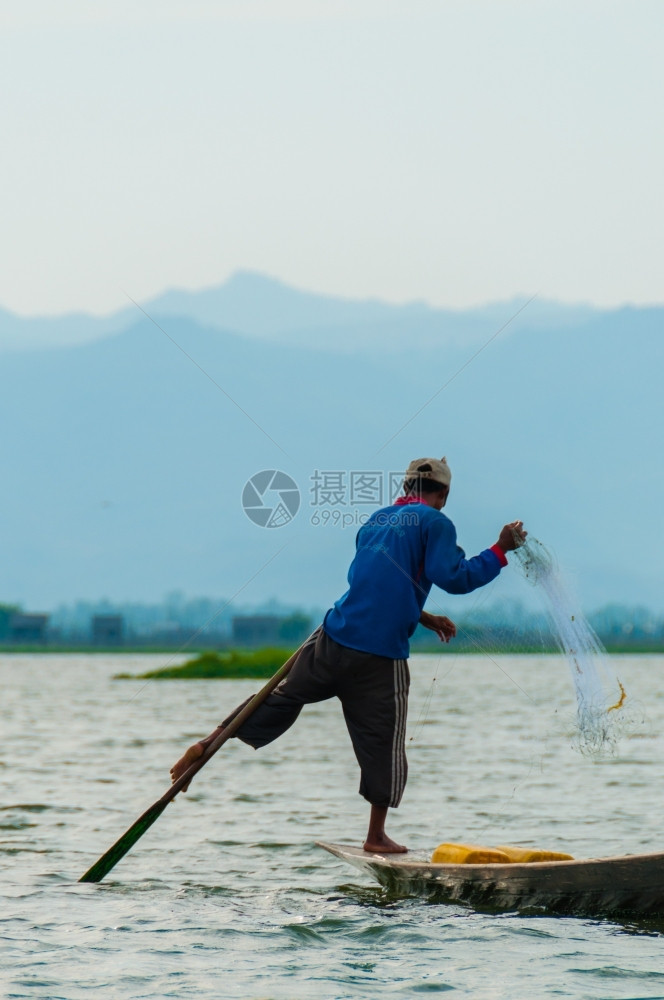 钓鱼茵莱湖的渔夫在一只脚上工作茵莱湖的渔夫在一只脚上工作缅甸划船日落图片