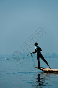 农村水旅游茵莱湖的渔夫在一只脚上工作茵莱湖的渔夫在一只脚上工作缅甸图片