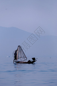 划船茵莱湖的渔夫在一只脚上工作茵莱湖的渔夫在一只脚上工作缅甸景观农业图片