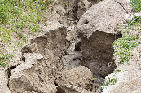 山路大雨后土壤侵蚀在绿种植被下大雨后山区道路上的土壤被毁坏山道上大雨后土壤流失水分生态风景背景图片