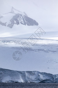 冷若冰霜川边缘雪笼罩的山上冰雪沉落在雾中光线照亮图片