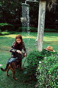 年轻的汗基里亚洲妇女洗宠物狗图片