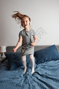在床上跳跃的小女孩跳舞高清图片素材