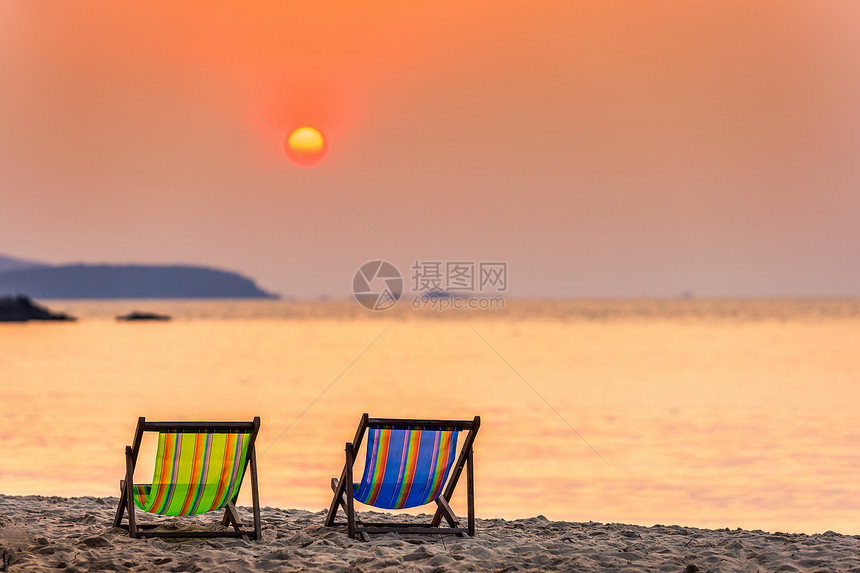 蓝色的水日出在沙热带滩和海浪两座甲板椅上美日初落夏在泰国尚塔胡里岛的礼帽卡休海滩上度过图片