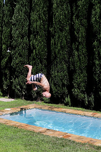 闲暇一个男人跳进游泳池翻过跳到水里休息度假在海边美丽的景色幸福一种图片
