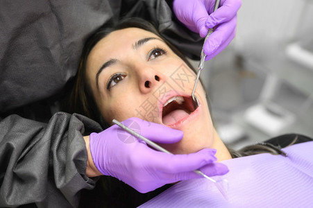 年轻女子在牙科诊所治疗牙齿图片