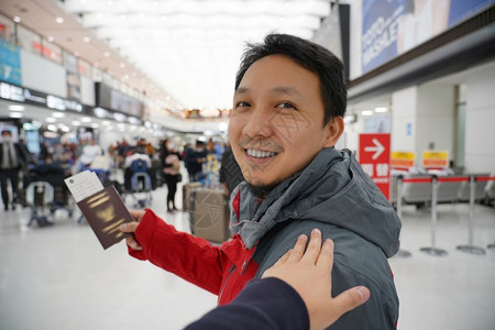 候机时手抚亚洲肩在机场迎接朋友手拿大行李护照旅客和友好的概念现代经过肖像目的地高清图片素材